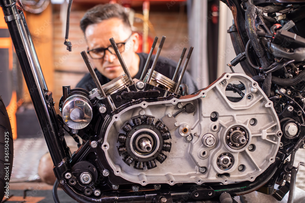 Wall mural mechanic working on the repair of a motorcycle in the workshop