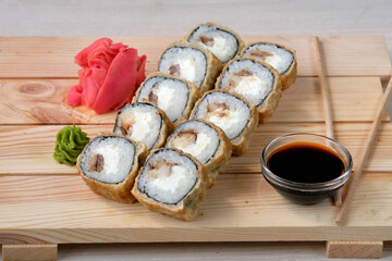 Sushi breaded rolls with Prawns, cream cheese, white rice, wasabi, soy sauce and pickled ginger. Tasty and artistic food for restaurant or cafe menu.