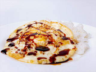 Fried egg or sunny side up, served with white rice and soy sauce, on a white plate, isolated in white background. Space for text