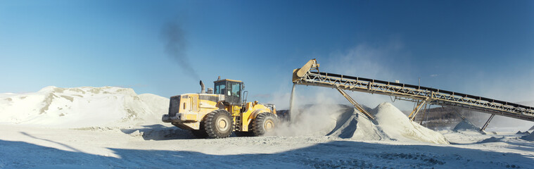 Front-end loader and stone crushing equipment on the mining enterprise, panorama.