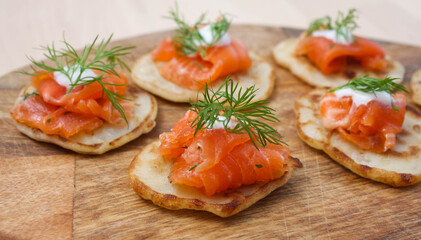 Pancakes with salted salmon on a wooden Board