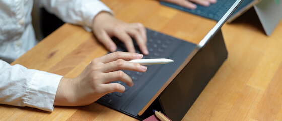 Female hand holding stylus pen pointing on tablet screen to consulting with her colleague