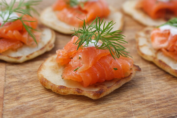 Pancakes with salted salmon on a wooden Board