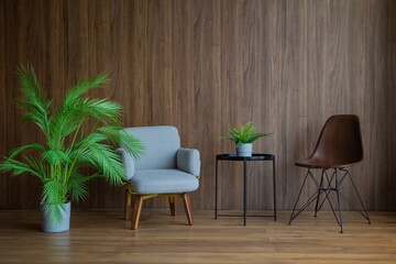 two chairs and a coffee table on a brown wall background
