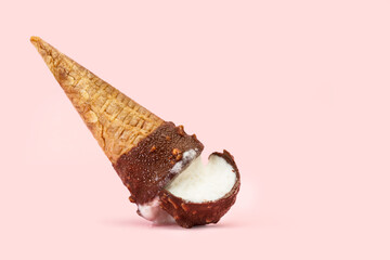 Cono de helado de chocolate y crema caído boca abajo sobre un fondo rosa pastel liso y aislado. Vista de frente. Copy space - obrazy, fototapety, plakaty
