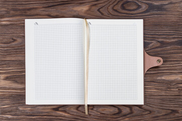 Open daily planner on wooden background. Copyspace template and branding mockup.