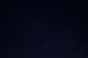 Long exposure night photo of a bright stars. A lot of stars with constellations. Far from the city. Night landscape.