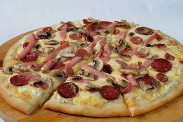 Pizza with mushrooms, mozzarella  and sausages. Delicious Italian food. Cafe, pizzeria and restaurant menu. 