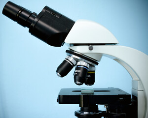 Electron microscope on a blue background. An electron microscope is used in medecine for analysis...