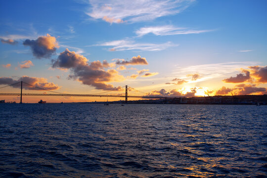 View of Bridge in Lisbon in the Twilight . Scenery of Tagus River and Ponte 25 de Abril 