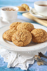 Sesame cookies and cup of tea, sweet breakfast on blue background