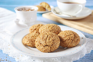 Sesame cookies and cup of tea, sweet breakfast on blue background