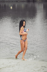 Young beautiful woman with beautiful body with american flag on the beach