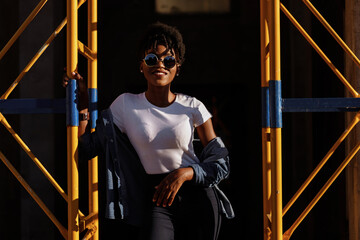 black girl near construction site in the city in sunlight