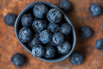 Blueberries in a small bowl on a red old background