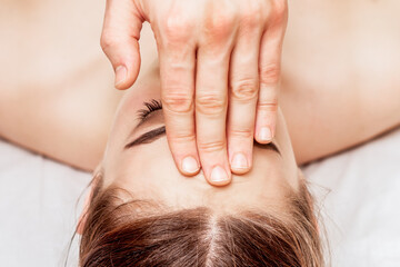 Fototapeta na wymiar Forehead massage of young woman, close up.