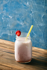 strawberry smoothie on a wooden table. blue background