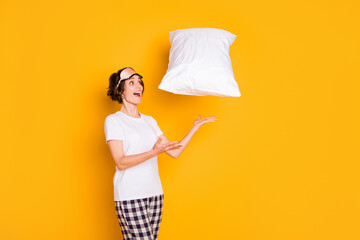 Portrait of her she nice attractive lovely pretty charming cheerful cheery girl having fun playing with white pillow isolated on bright vivid shine vibrant yellow color background