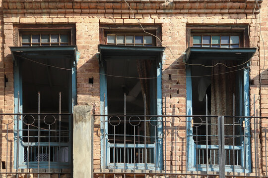 Three windows of old building opened