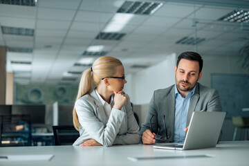 Two business people discussing work, portrait.