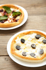 Delicious italian pizzas on grey wooden table. Vertical foto