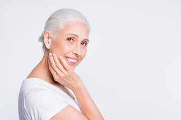 Close up photo of charming lady touching her face with fingers smiling at camera isolated over white background