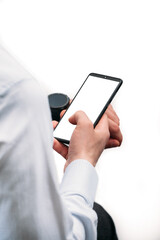 A business man in a shirt holds a phone with a white screen on a white background.  Photo with a place for an inscription. Photo for the designer. Isolate the photo. Smart watch on the hand..