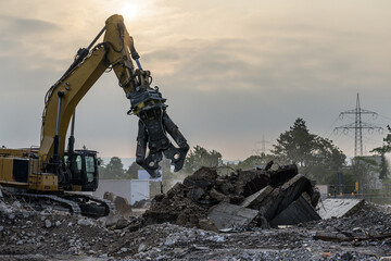 Building House Demolition site Excavator with hydraulic crasher machine and yellow container