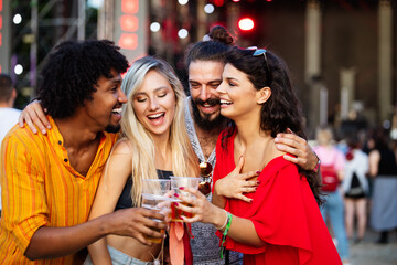 Happy young group of friends attending festivals at summer