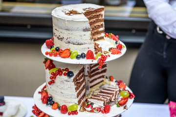 Obraz na płótnie Canvas beautiful delicious Wedding cake in many tiers with fresh wild berries and fruits