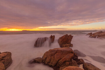 Waves flowing over rocks at Zenith Beach.At sunrise.Shoal Bay,Port Stephens.Hunter Region of N.S.W. East Coast of Australia.