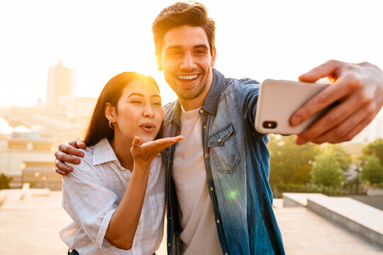 Image Of Happy Couple Blowing Air Kiss And Taking Selfie On Cellphone