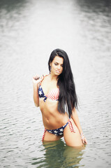 Obraz premium Young sexy woman on the beach in the swimsuit