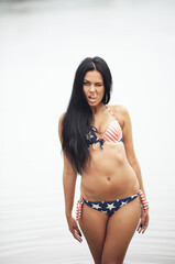 Obraz premium Young sexy woman on the beach in the swimsuit