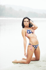 Young sexy woman on the beach in the swimsuit