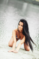 Young sexy woman on the beach in the swimsuit