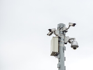 Closeup photo of a column with many surveillance cameras