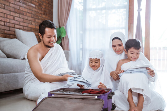 muslim family hajj and umrah pilgrim with children packing at home