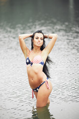 Obraz premium Woman on the beach in a bathing suit with an American flag having fun