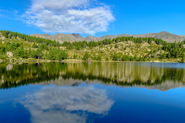 Fototapeta na wymiar Morning reflections at the lake in the France Pyrenees, Capcir (Cerdanya Province, the Carlit Lakes)