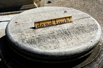 Greece, Athens, June 16 2020 - 'Do not touch' warning on the basis of ancient marble column at the archaeological site of Olympieio or Temple of Olympian Zeus.