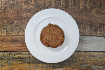 나무 테이블에 있는 아마씨, 오트밀,코코넛,견과류 넣은 수제 쿠키 하나 , 건강한 채식주의자