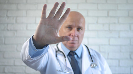 Confident Doctor Making a Stop Hand Gestures in a Hospital Room Behind a Glass Panel 