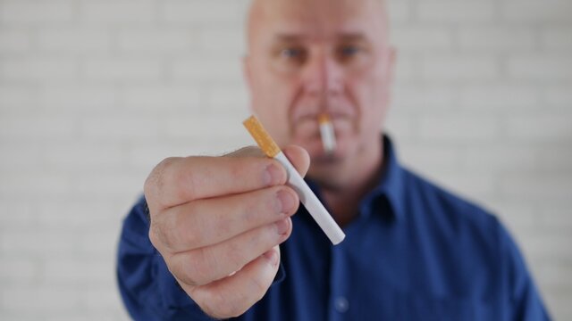 Image of a Businessman Who Smokes Relaxed and Offers a Cigarette to Another Person