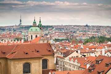Fototapeta na wymiar View of red roofs of Prague along with St. Nicholas church and Zizkov tower