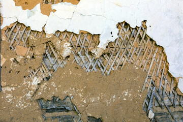 Background texture of old plaster on the wall with remnants of white paint, primer and wooden...