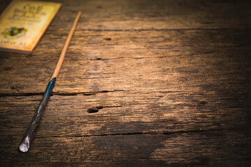 Obraz premium Magic wand on wooden table, Magic wand Wizard tool on vintage wooden background.