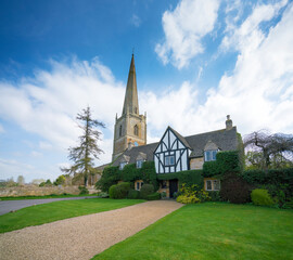 Fototapeta na wymiar St Mary's Church and churchyard a blue sky day. Painswick is a town in the Cotswolds UK.