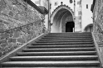 Fototapeta premium Moody black and white stairs and entrace to St. Vitus church in Cesky Krumlov without people during lockdown