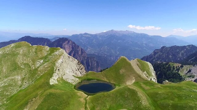 Aerial drone video from iconic and beautiful lake Drakolimni of Tymfi mountain which resides at high altitude above sea, Vikos National Park, Zagori, Greece